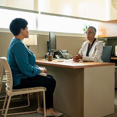 Woman talking to woman representing a healthcare provider in a doctor’s office